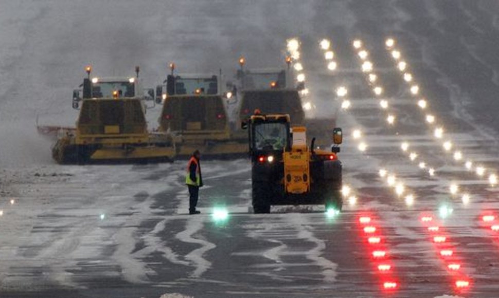 Darbininkai mėgina nuvalyti sniegą nuo lėktuvų kilimo tako Edinburgo oro uoste
