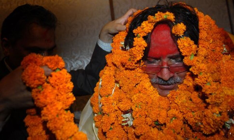Pushpa Kamalis Dahalas i&scaron;rinktas nauju Nepalo vyriausybės vadovu. Tradici&scaron;kai jis pasveikintas gėlių girliandomis, veidas i&scaron;teptas raudonais dažais.