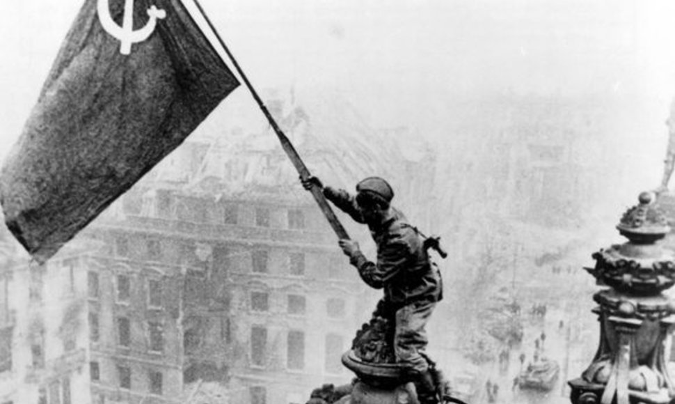 Garsioji nuotrauka, kaip rusų kareiviai kelia ant Reichstago sovietų vėliavą.