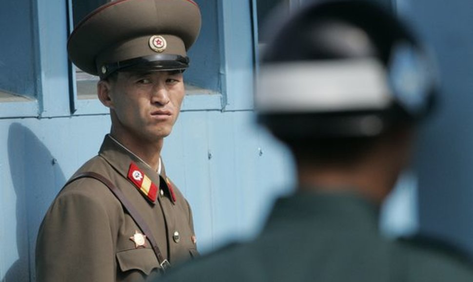 Šiaurės Korėjos kareivis (kairėje) ir Pietų Korėjo kareivis saugo Panmunjomo kaimą, kuris skiria šias dvi šalis.