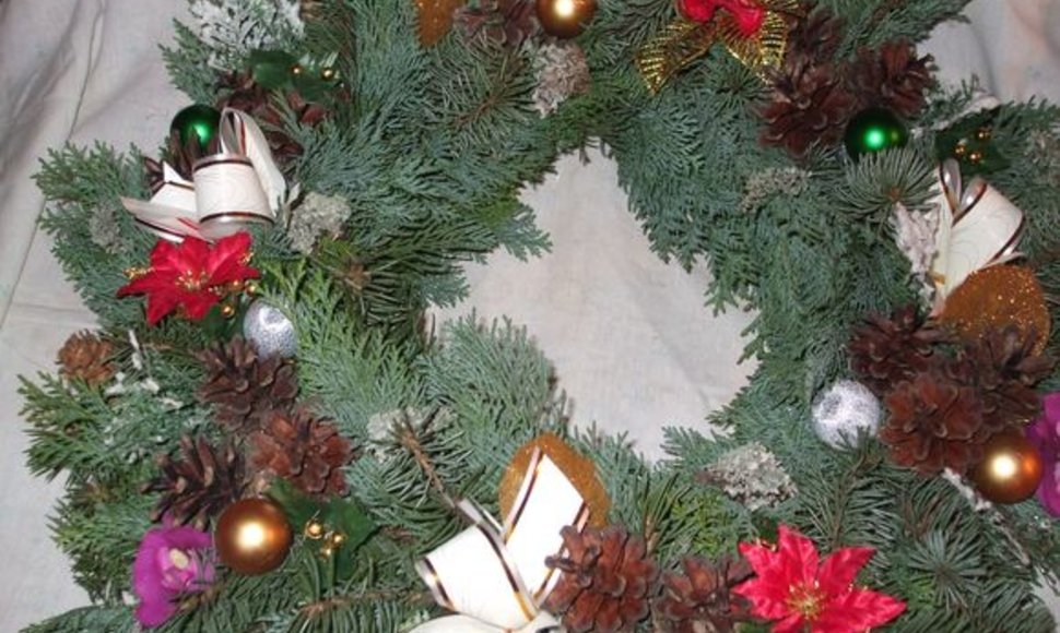 Karštais klijais Dalia priklijuoja kankorėžius, lapelius, įvairias išardytas kalėdines dekoracijas.