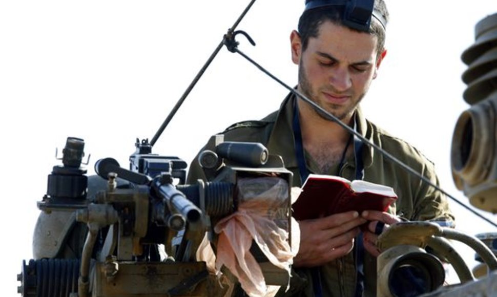 Izraelio karys išlipęs iš tanko skaito maldaknygę.