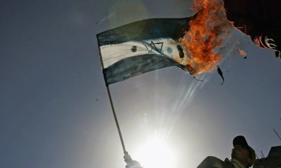 Palestinos protestuotojai degina Izraelio vėliavą.