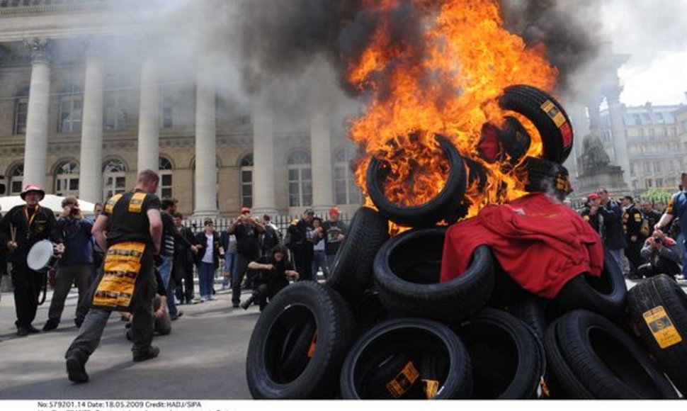 Protestuojantys darbininkai Paryžiuje degina padangas. 