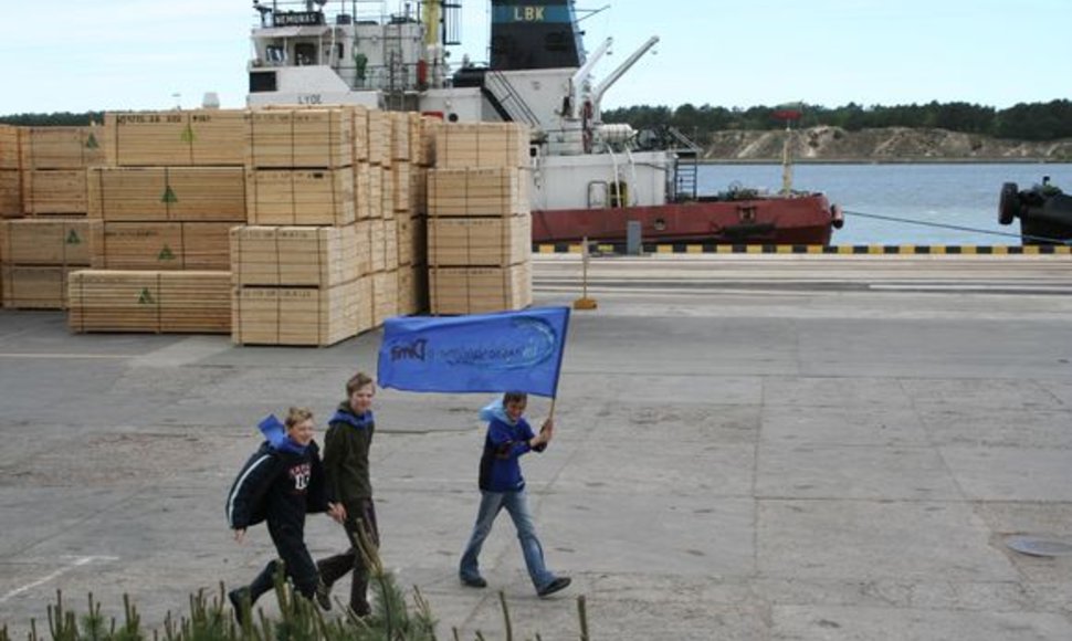 Moksleiviai su Vandenyno vėliava žygiuoja per Klaipėdos uostą.