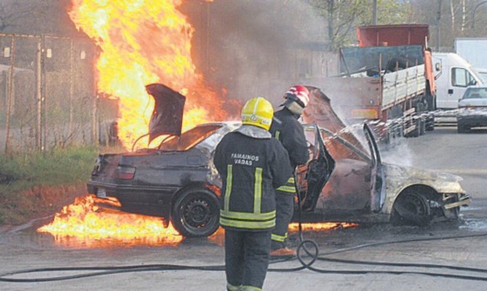 Ugniagesiai gesina automobilį.
