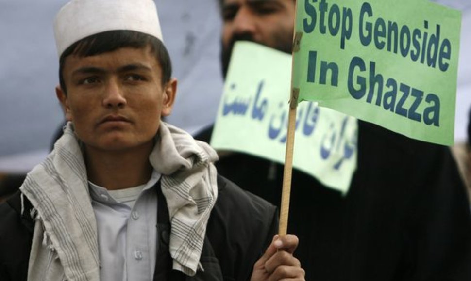 Protesto dalyvis Kabule, Aganistane, laiko rankose plakatą, kuriame raginama baigti antskrydžius Gazos ruože.