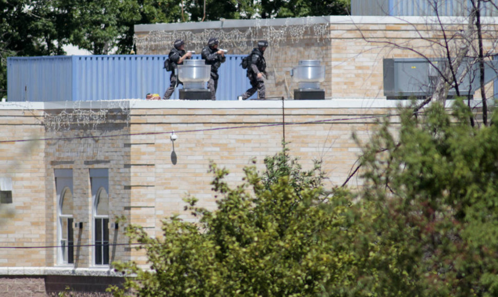 Policijos pareigūnai ant šventyklos stogo