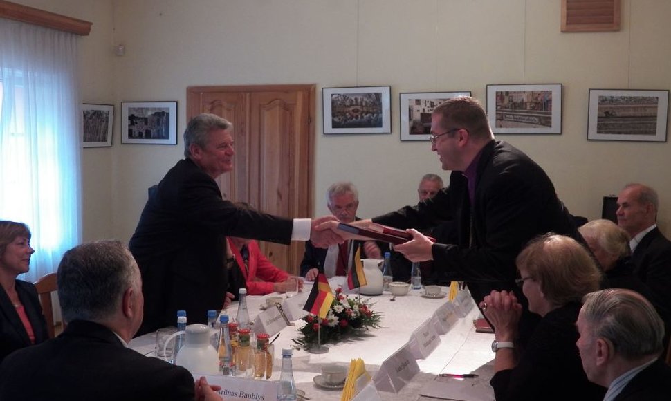 Rankas spaudžia Vokietijos prezidentas Joachimas Gauckas ir vyskupas Mindaugas Sabutis.