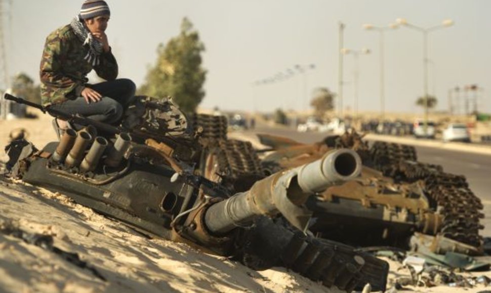 Sukilėlis tupi ant sunaikinto tanko prie Adždabijos.