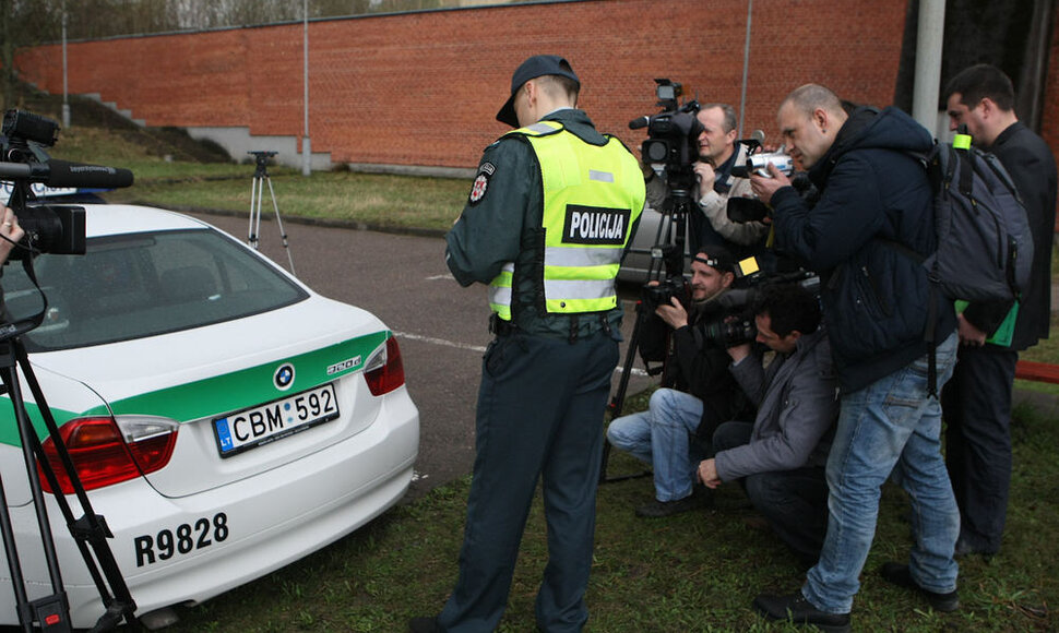 Kelių policininkas ant automobilio klijuoja lipduką „Aš neimu kyšio“