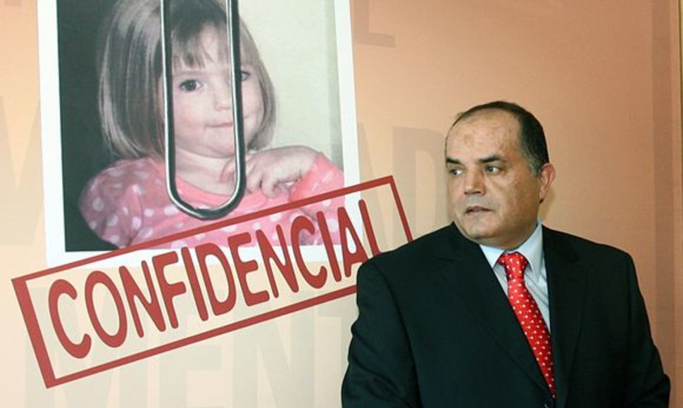 Detektyvas Goncalo Amaralas pozuoja šalia mergaitės plakato. 