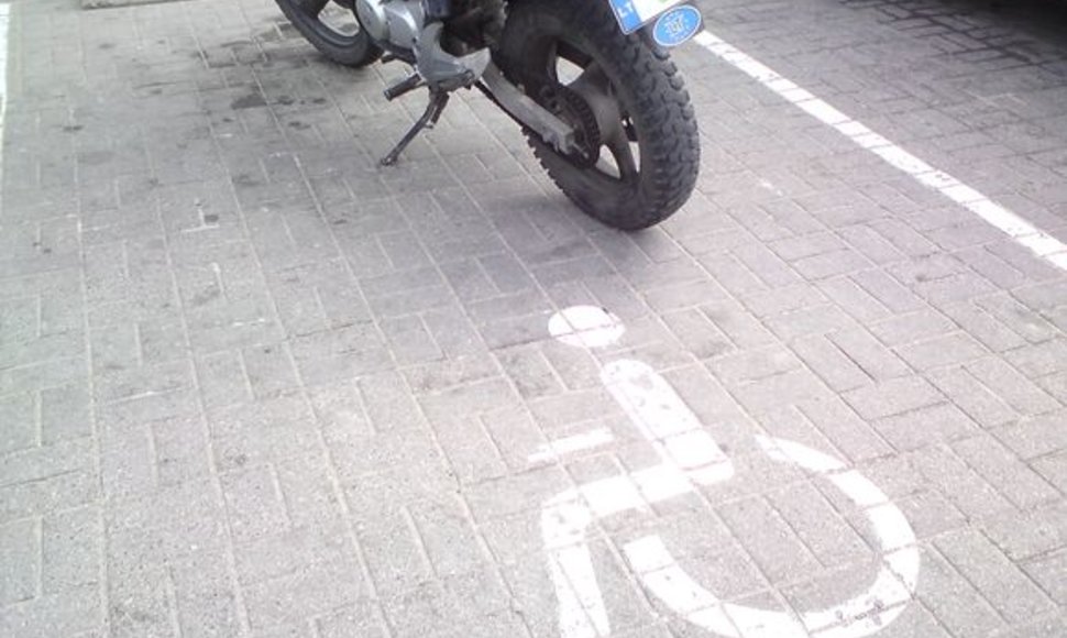Motociklas neįgaliųjų vietoje