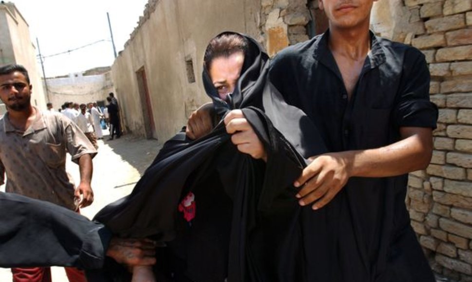 Prostitutė vedama iš vieno demaskuoto viešnamio Irake