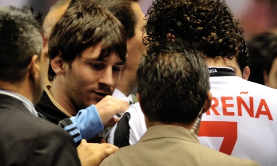 Lionelis Messi pasirašinėja ant Kosta Rikos futbolo rinktinės nario marškinėlių.