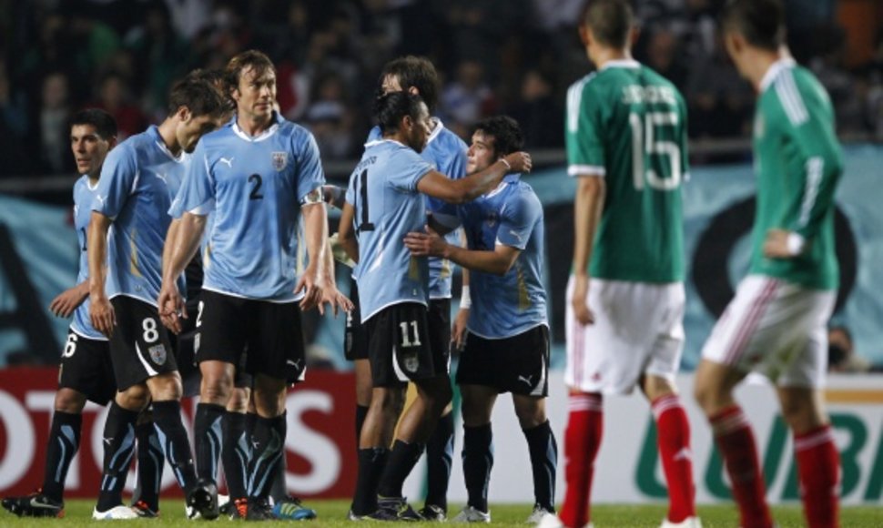 Urugvajaus futbolininkai džiaugiasi pergale.