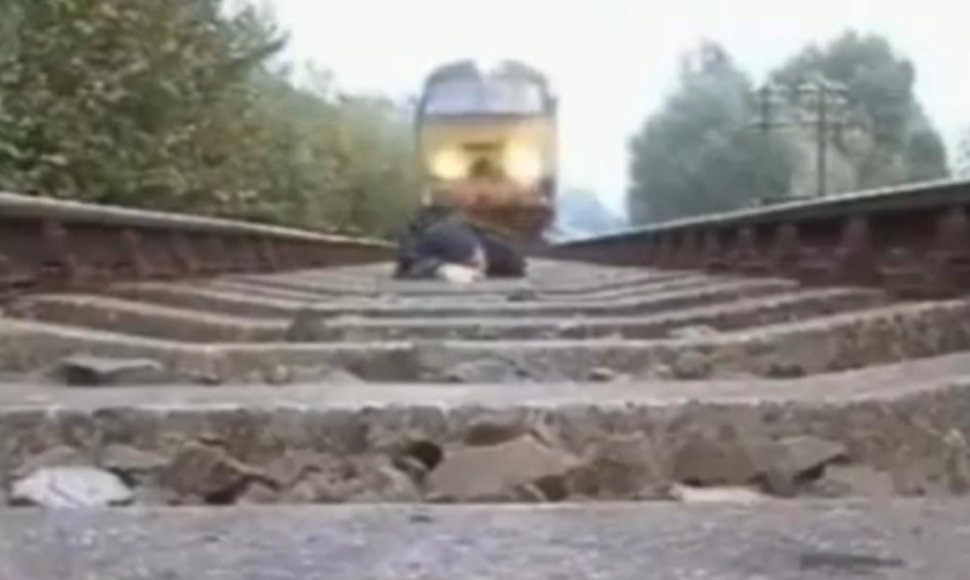 Vyras nusifilmavo, kaip virš jo pravažiuoja traukinys.
