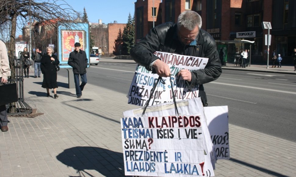 Į piketą Klaipėdoje kai kurie piketuotojai atsinešė krūvas plakatų ir ilgai ieškojo tinkamų šiam. 