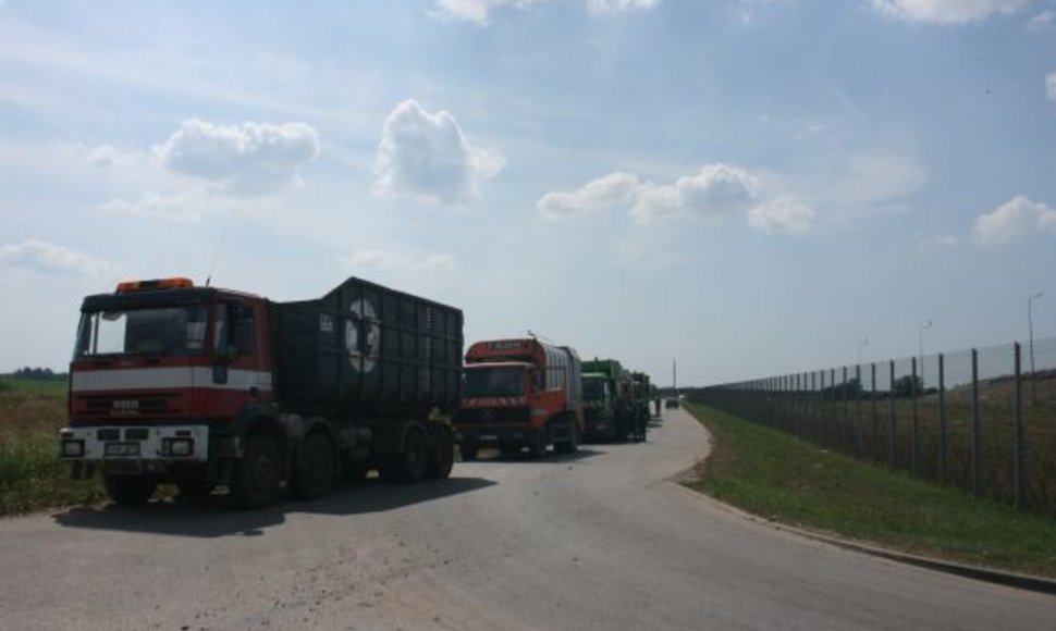 Prie sąvartyno nusidriekė atliekas gabenančių automobilių eilė.