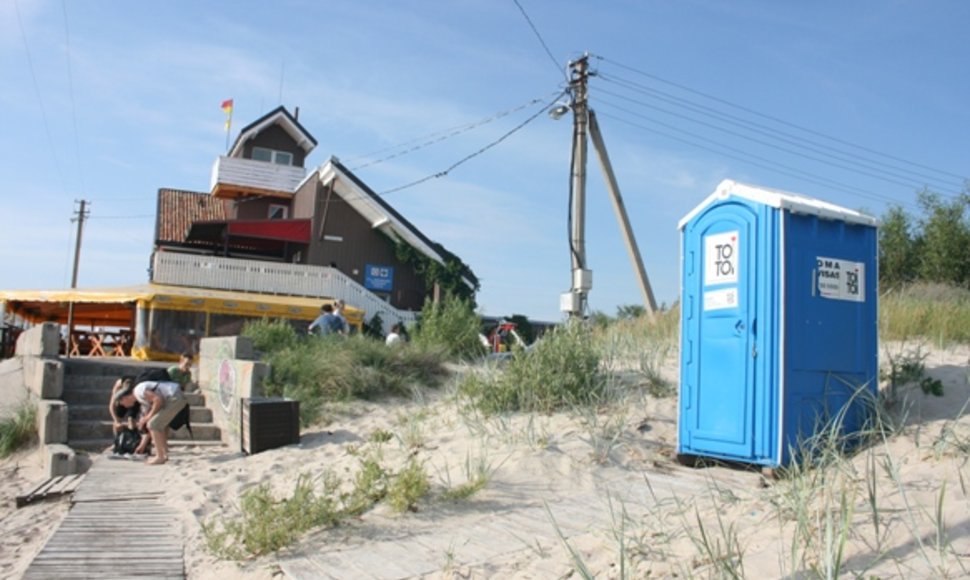 Ryškiaspalviai paplūdimiuose pastatyti tualetai poilsiautojams neprieinami – juos saugo tvirtos spynos.