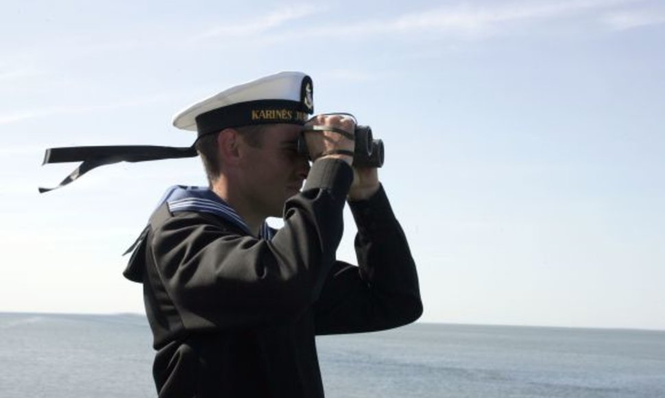 Karinių jūrų pajėgų karys stebi jūrą.