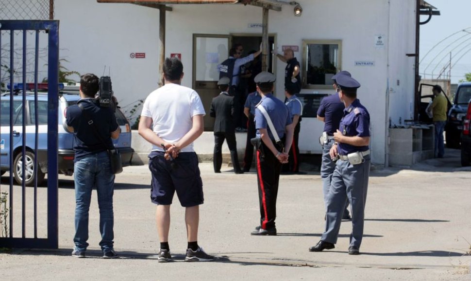 Italijos policija prie kuro saugyklos, kuri priklausė įtariamajam. 
