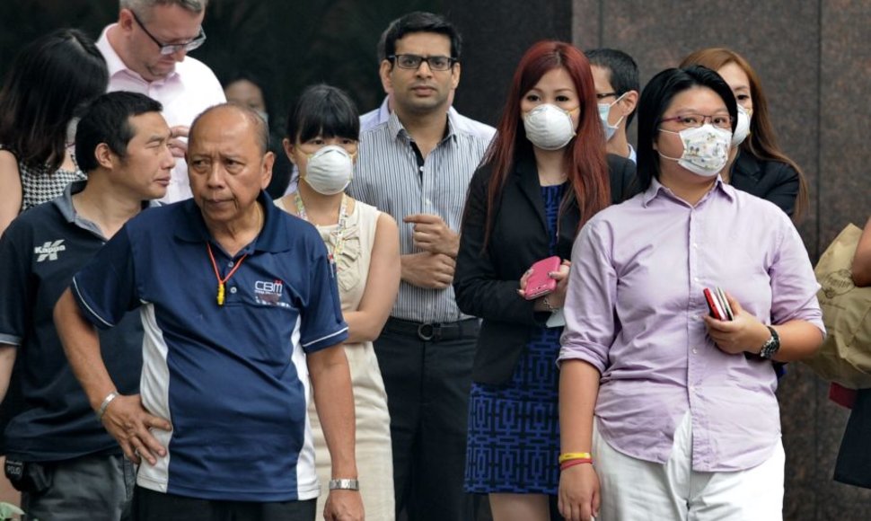 Singapūro žmonės nuo teršalų saugosi apsaugiinėmis kaukėmis.