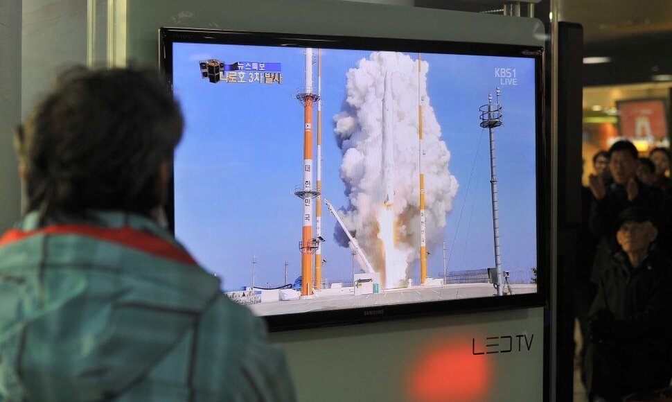 Žmogus stebi, kaip kyla Pietų Korėjos raketa, į orbitą nešanti palydovą