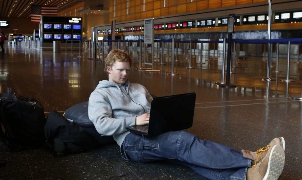 Žmogus dirba su kompiuteriu oro uoste