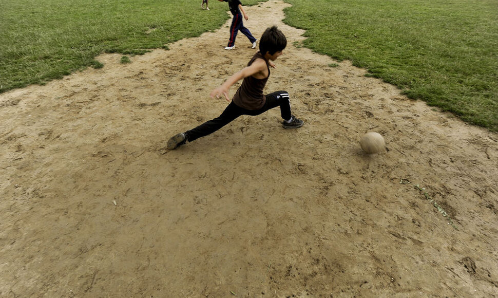 Vaikai žaidžia futbolą Kosovo Respublikoje.