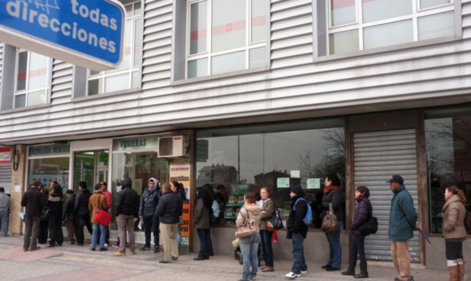 Žmonės laukia prie įdarbinimo biurio Madrido rajone.