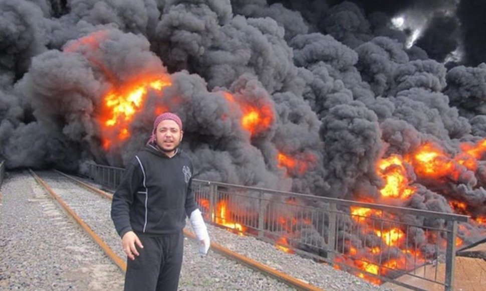 Vyras stovi netoli degančio naftotiekio Homse.