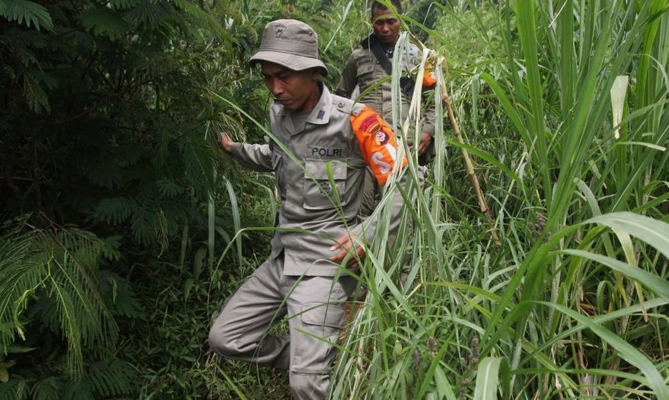 Indonezijos policininkai eina link „Sukhoi Superjet-100“ sudužimo vietos