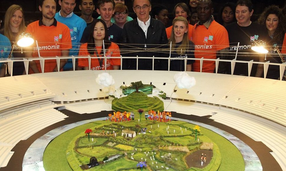 Prodiuseris Danny Boyle'as (centre) prie Londono olimpinių žaidynių stadiono maketo.