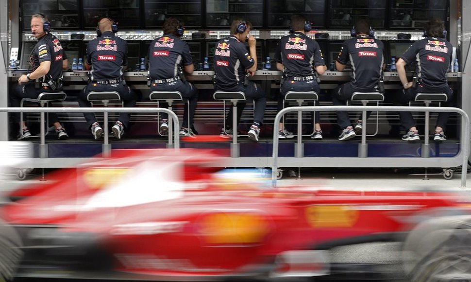 Fernando Alonso „Ferrari“ važiuoja pro „Red Bull“ komandos inžinierius