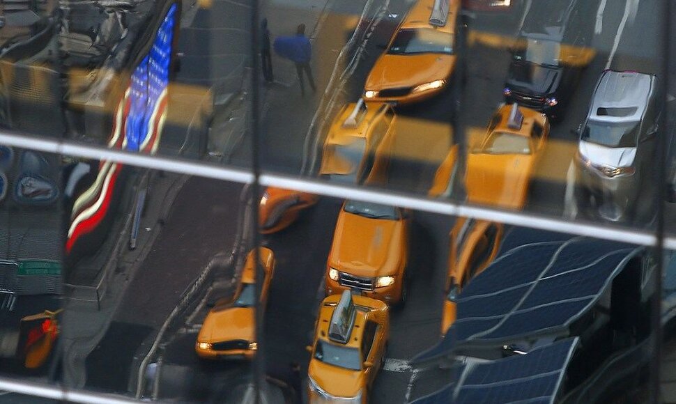 Taksi automobiliai atsispindi Niujorko pastato lange