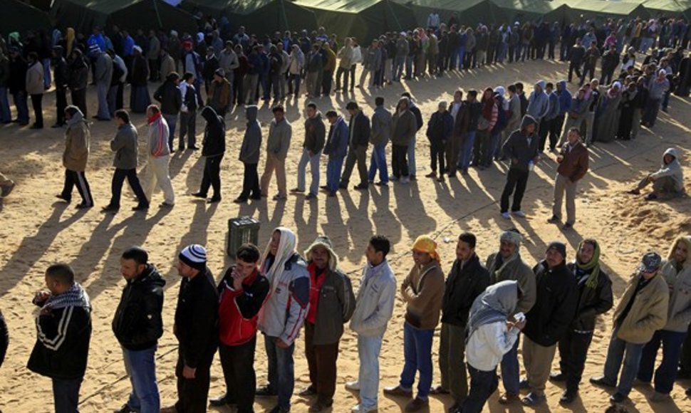 Išalkę ir pavargę žmonės pabėgėlių stovykloje laukia eilėje prie maisto.