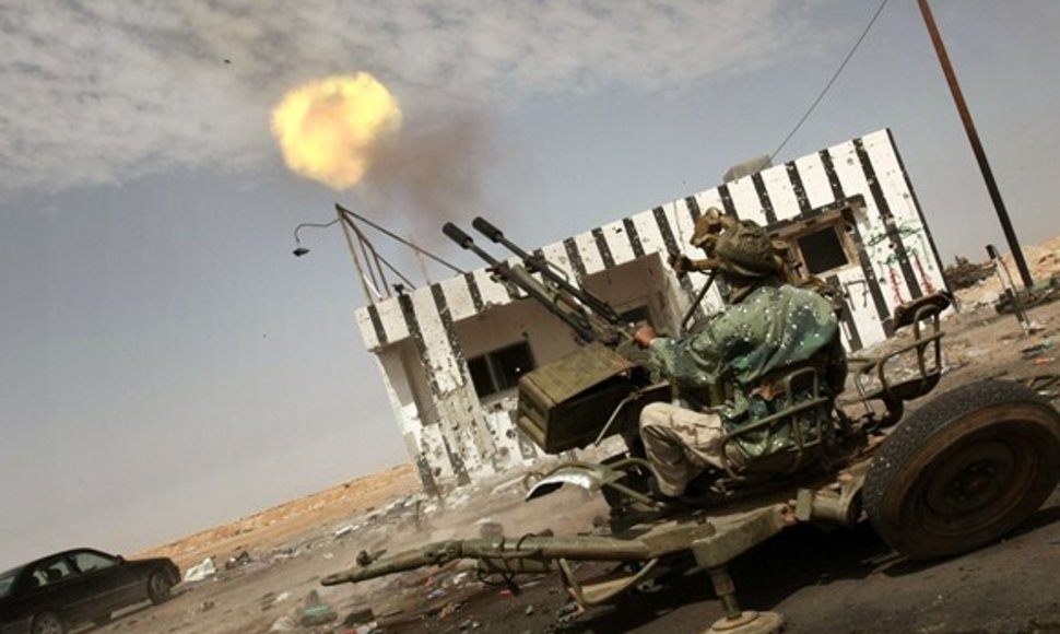 Libijos sukilėlis šaudo su priešlėktuviniu ginklu.