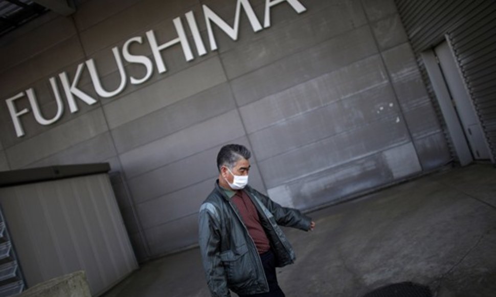 Vyras eina į Fukušimos evakuacijos centrą.