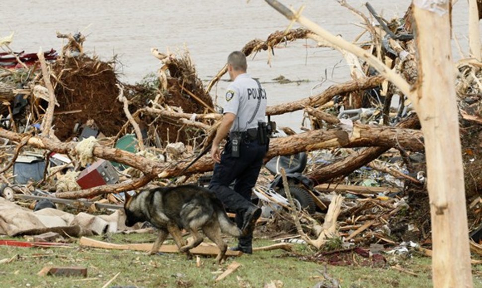 Policininkas su šunimi ieško per tornadą dingusių žmonių.