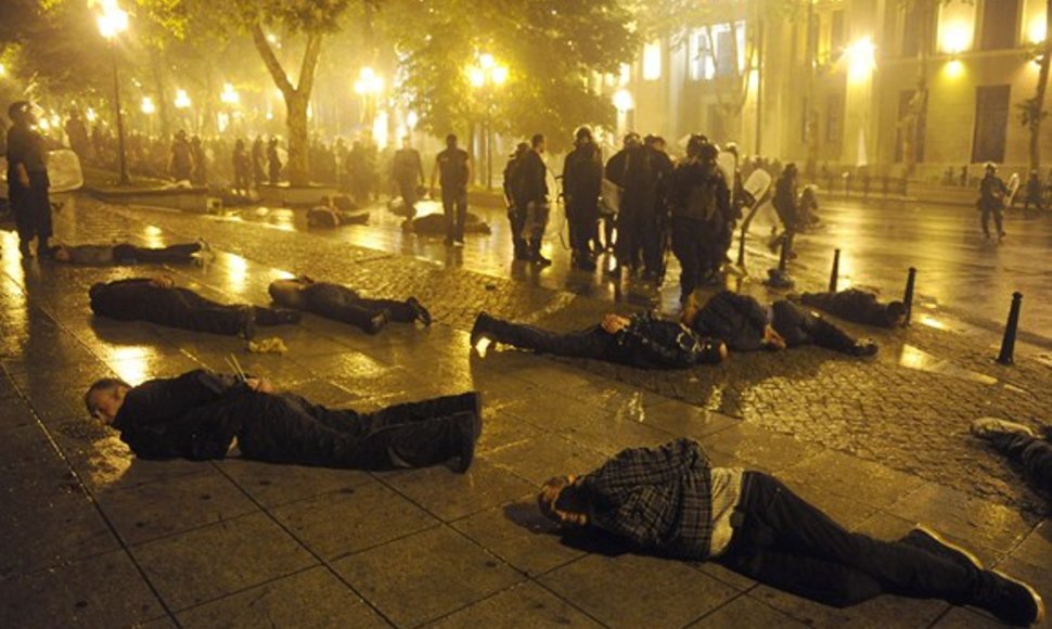 Ant grindinio guli policijos sulaikyti protestuotojai.
