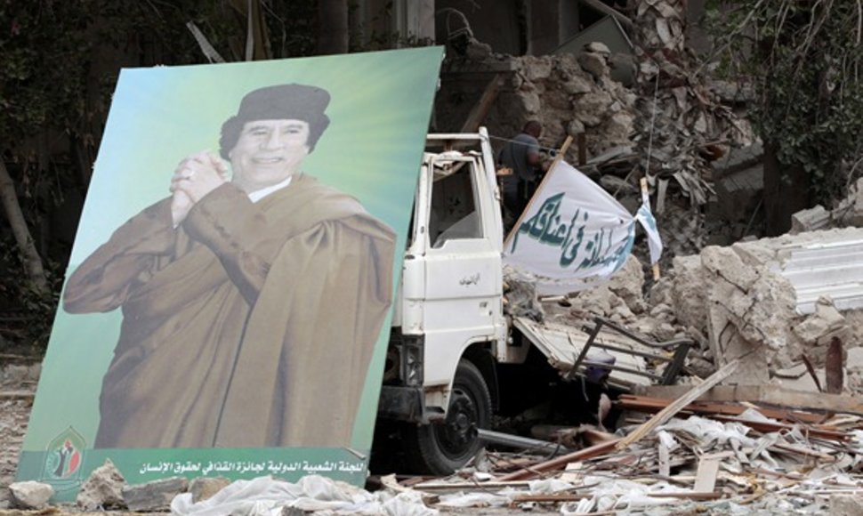 Muamaro Kadhafi plakatas prie sugriuvusio pastato Tripolyje