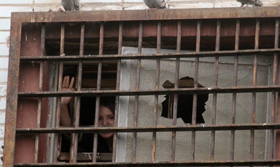 Mergina mojuoja pro kalėjimo grotas Minske.