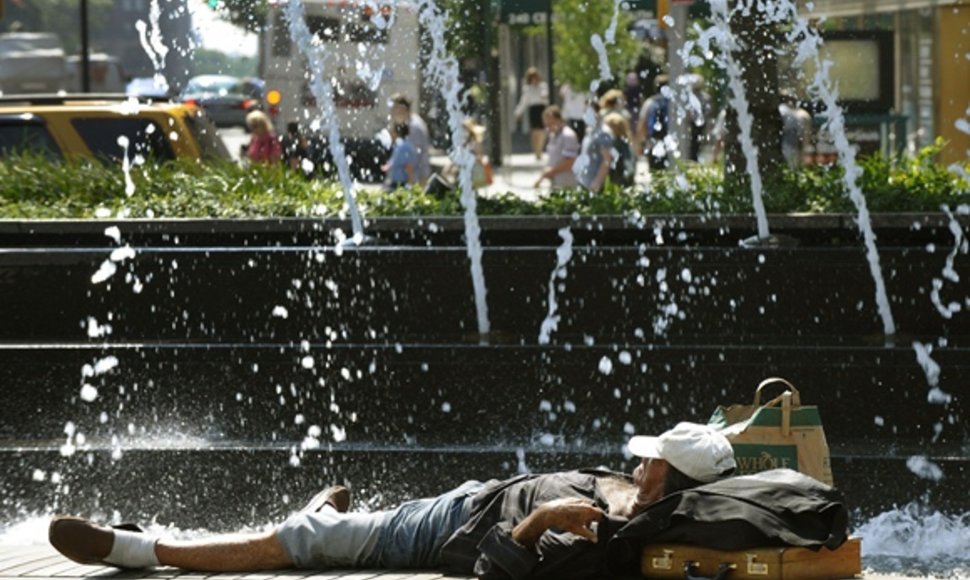 Vyras guli šalia fontano.