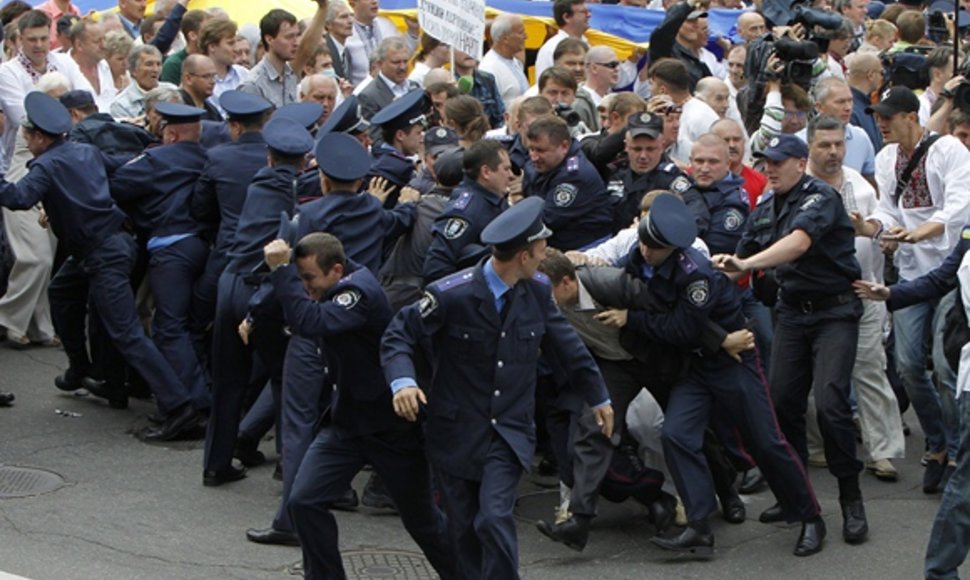 Policininkai bėga nuo protestuotojų.