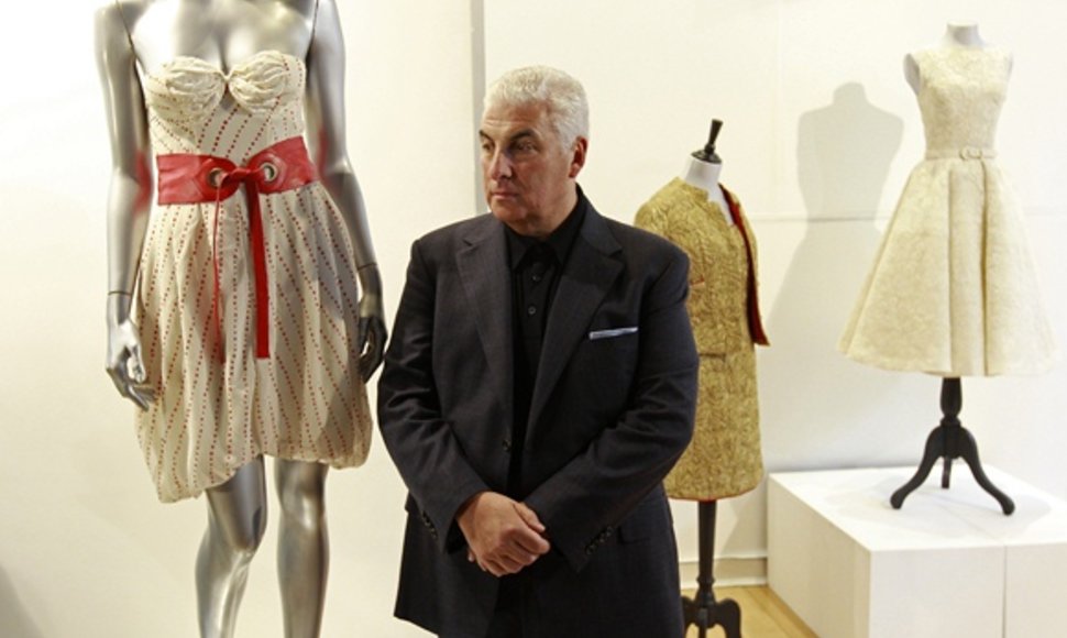 Amy Winehouse tėvas Mitchas pozuoja fotografams šalia suknelės.