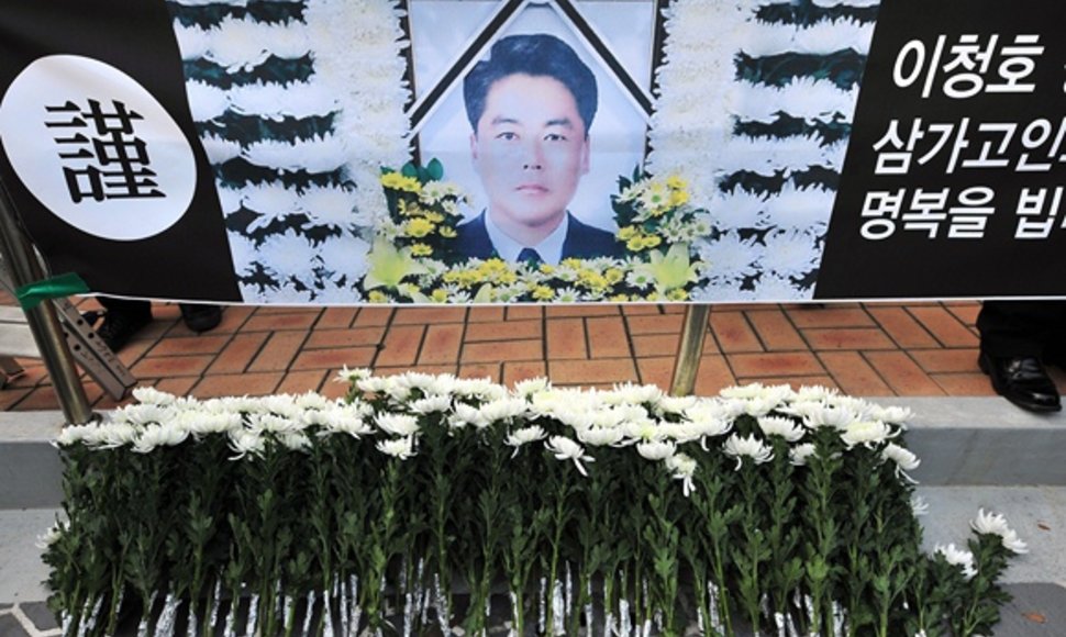 Gėlės prie žuvusio Pietų Korėjos pakrančių sargybos pareigūno Lee Cheong-Ho portreto