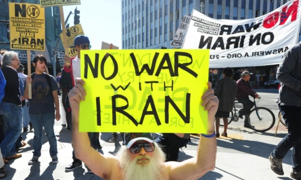 Protestuotojas, laikantis plakatą, kuris ragina nekariauti su Iranu