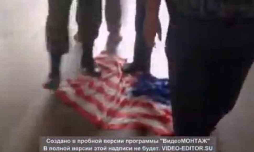 Rusai spardo JAV vėliavą.