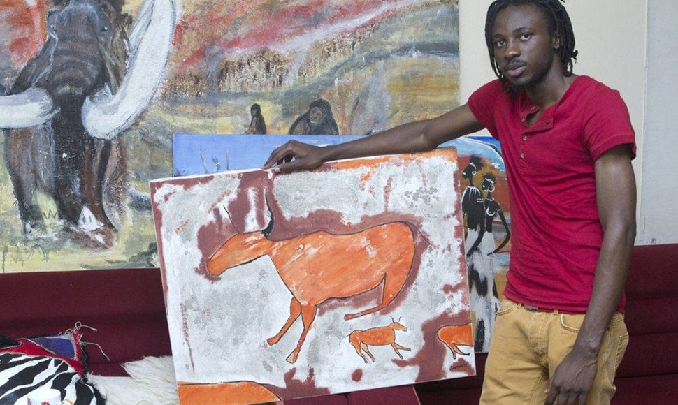 Princas iš Kamerūno prie tapybos paveikslų afrikietiškais motyvais